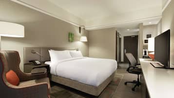 Une chambre d’hôtel équipée d’un lit, d’un bureau, d’une chaise, d’une lampe et d’un téléviseur.