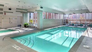 An indoor swimming pool with clear water, marked lanes, and a sunlit area with lounge chairs. - Homewood Suites by Hilton Calgary Downtown (Calgary)