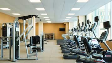 Een fitnessruimte met loopbanden, elliptische trainers en krachtapparaten.