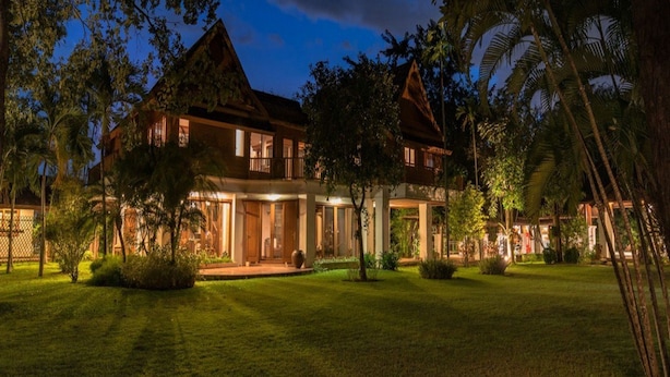A large, two-story house with a well-maintained lawn and trees. - Taladya Chiang Mai Homestay (Doi Saket)