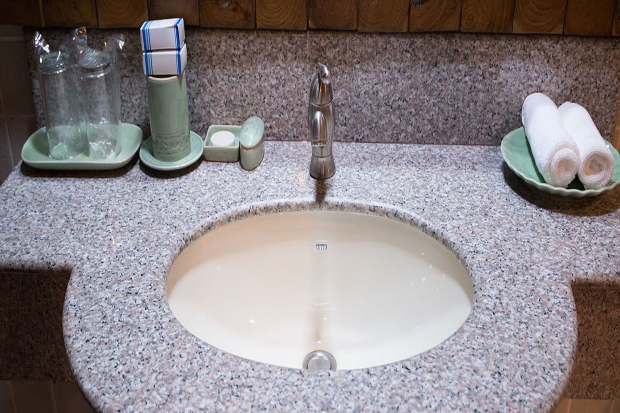 A granite countertop with a sink, a faucet, and a soap dish.