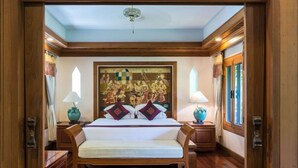 A bedroom with a bed, two nightstands, a ceiling fan, and a large tapestry on the wall. - Taladya Chiang Mai Homestay (Doi Saket)