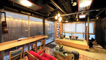 A modern interior with a seating area, a coffee table, and a view through large windows.