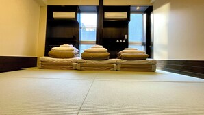 Habitación de hotel con una cama grande, dos unidades de aire acondicionado y vista al exterior por una ventana.