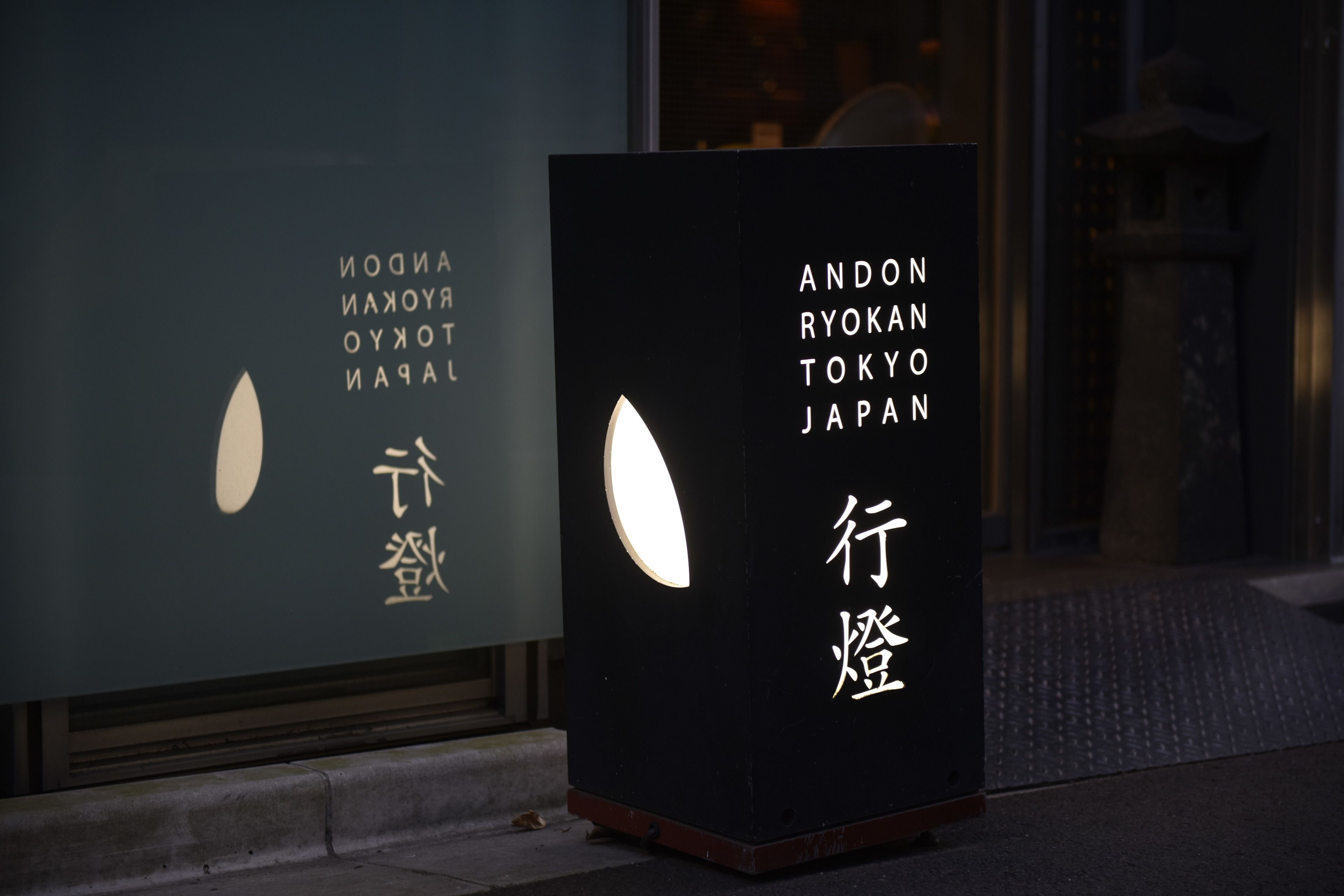 Une enseigne avec des caractères japonais et les mots « Andon Ryokan Tokyo Japan ».