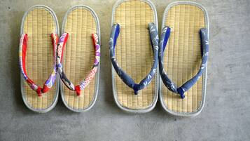 Four pairs of flip-flops with different colored straps laid out on a concrete floor.