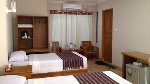 Una habitación de hotel con dos camas, un armario, un escritorio, una silla, una cafetera y un refrigerador.