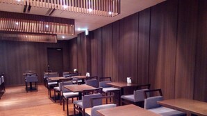 A modern dining area with wooden tables and chairs, a wooden ceiling with vertical slats, and a polished wooden floor. - Hotel Crown Hills Sendai Aobadori (Sendai)