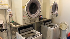 A laundry facility with two front-loading washing machines and a dryer. - Hotel Crown Hills Sendai Aobadori (Sendai)