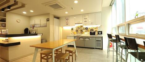 Una cocina moderna con una isla central, sillas de madera y una zona de bar con taburetes.