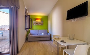 Relax in a comfortable space with a sofa, small table, and flat-screen TV.