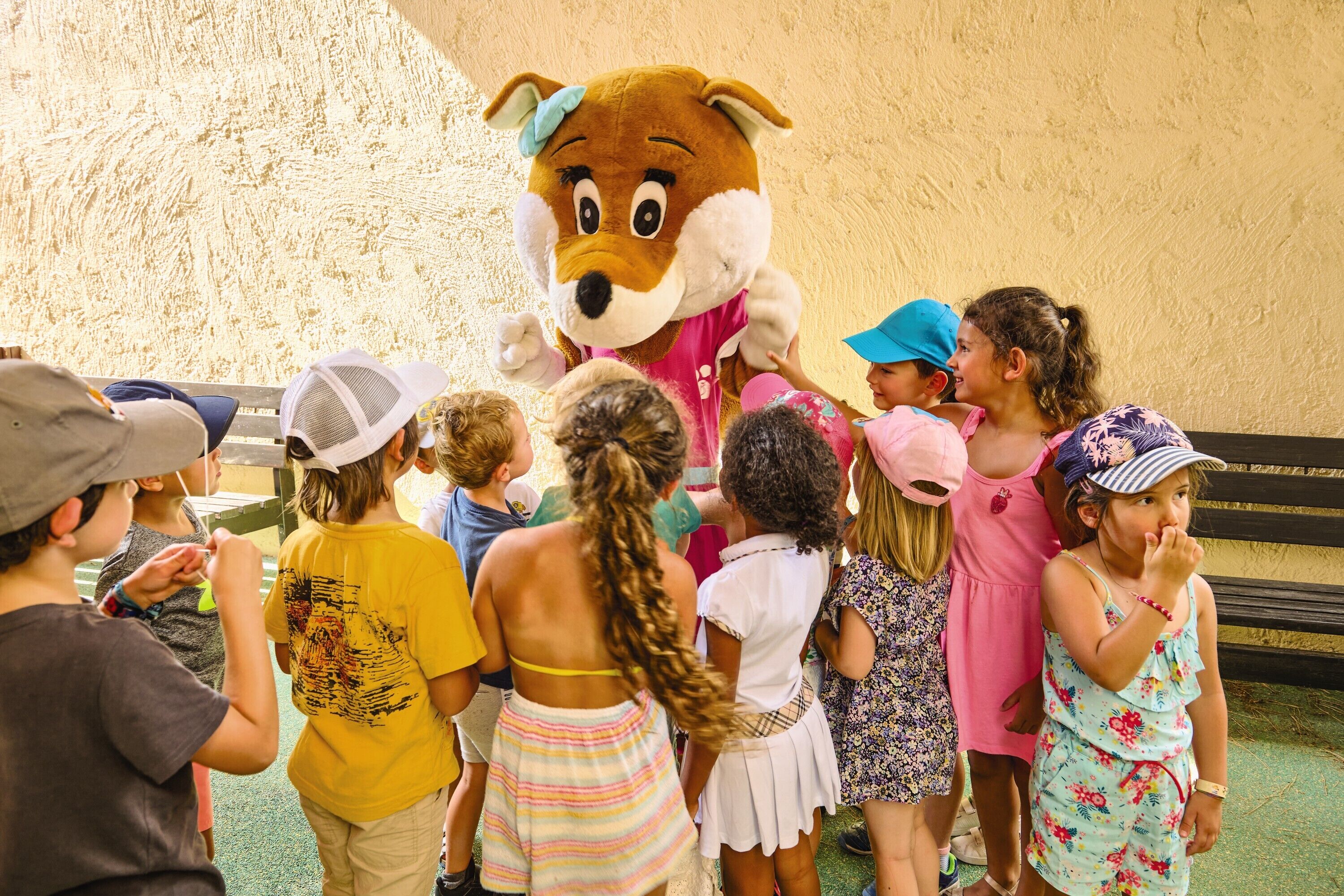 Un groupe d’enfants interagissant avec un grand personnage-mascotte.