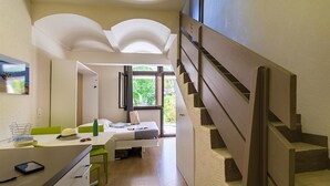 A modern hotel room with a staircase, a bed, a desk, and a view of greenery outside. - Belambra Clubs La Colle-sur-Loup - Les Terrasses De Saint-Paul De Vence (La Colle-sur-Loup)