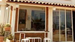 A two-story building with a balcony, large windows, and a sliding glass door. - M'ama Holiday Rooms (Palermo)