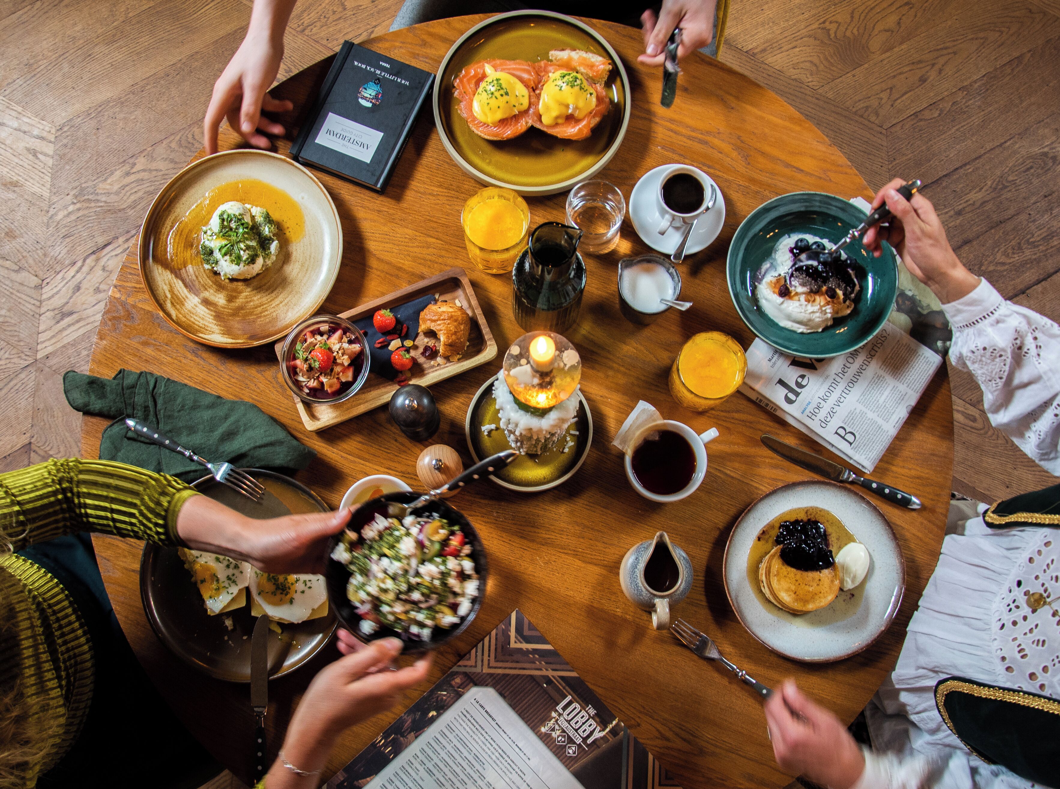 A round table with various dishes, drinks, and a menu.