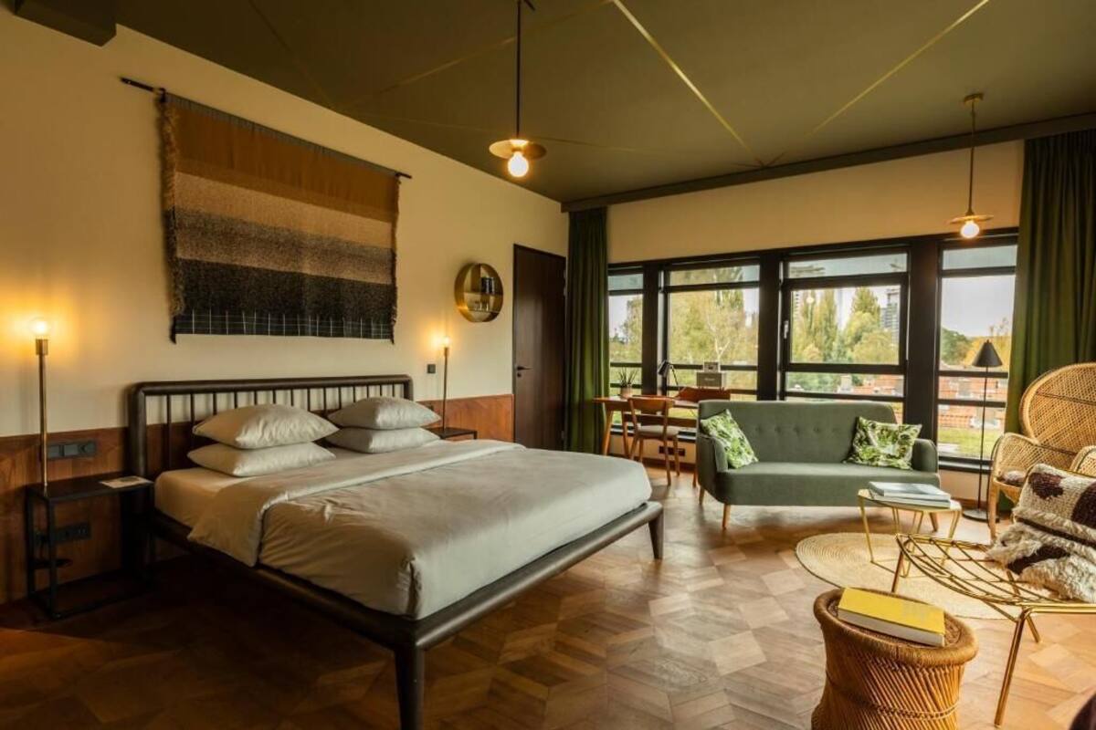 Une chambre d’hôtel équipée d’un lit, d’un canapé, d’une table à manger et offrant une vue sur l’extérieur.