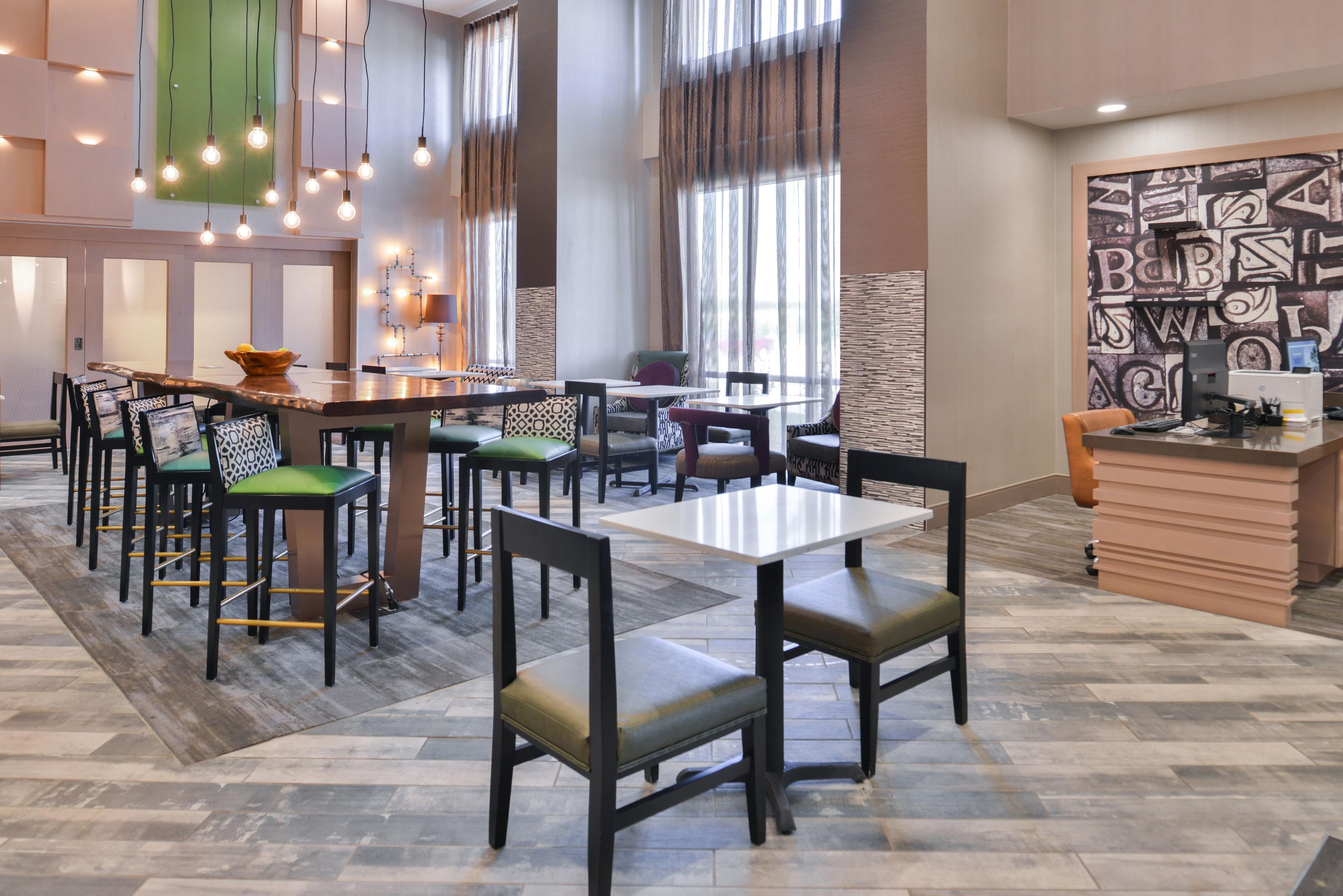 Ein modernes Restaurant mit mehreren Sitzbereichen, darunter eine Bar und einzelne Tische.