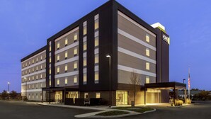 A multi-story hotel with a modern design, featuring a prominent 'HOME' sign on the facade.