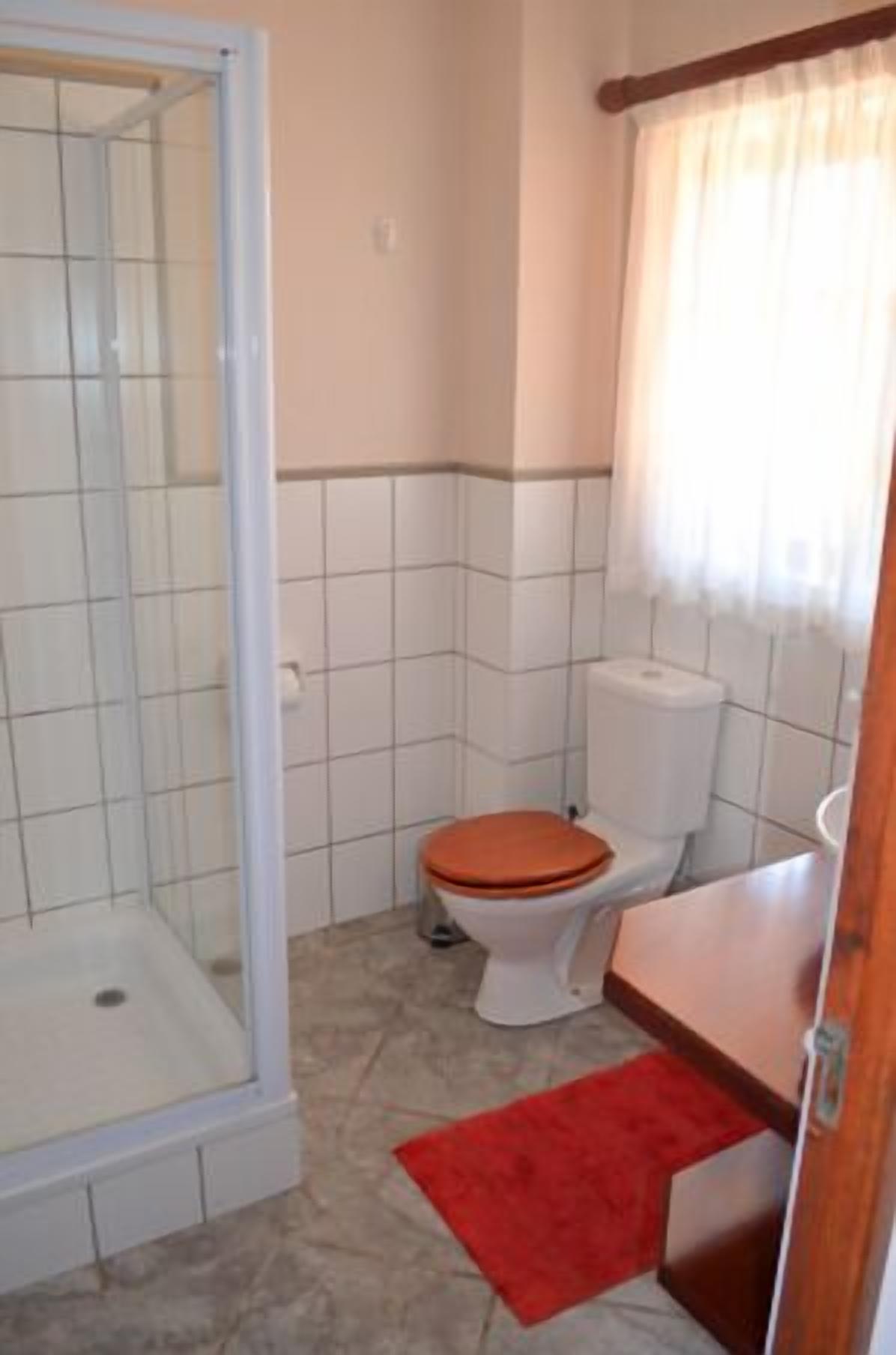 Ein kleines Badezimmer mit Dusche, Toilette und Waschbecken.