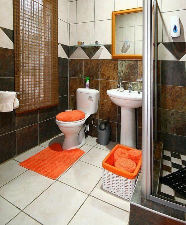 A bathroom with a toilet, sink, and shower. - Home Guesthouse (Rustenburg)