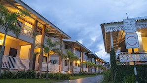 A hotel with multiple balconies, a covered walkway, and a sign indicating a resort. - The Heart of Pai Resort (Pai)
