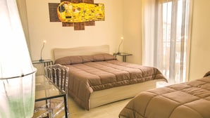 Quarto com cama grande, mesa de vidro e um quadro na parede.