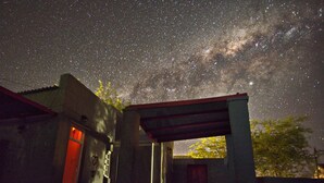 A building with a covered entrance and a starry night sky above. - The Ibis Lounge (Nieu-Bethesda)