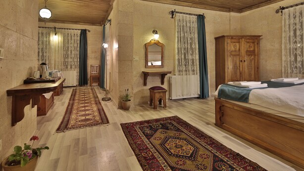 Una habitación tradicional con una cama de madera, una mesita, un espejo y un radiador.