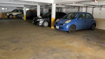Un estacionamiento con tres coches aparcados en fila.