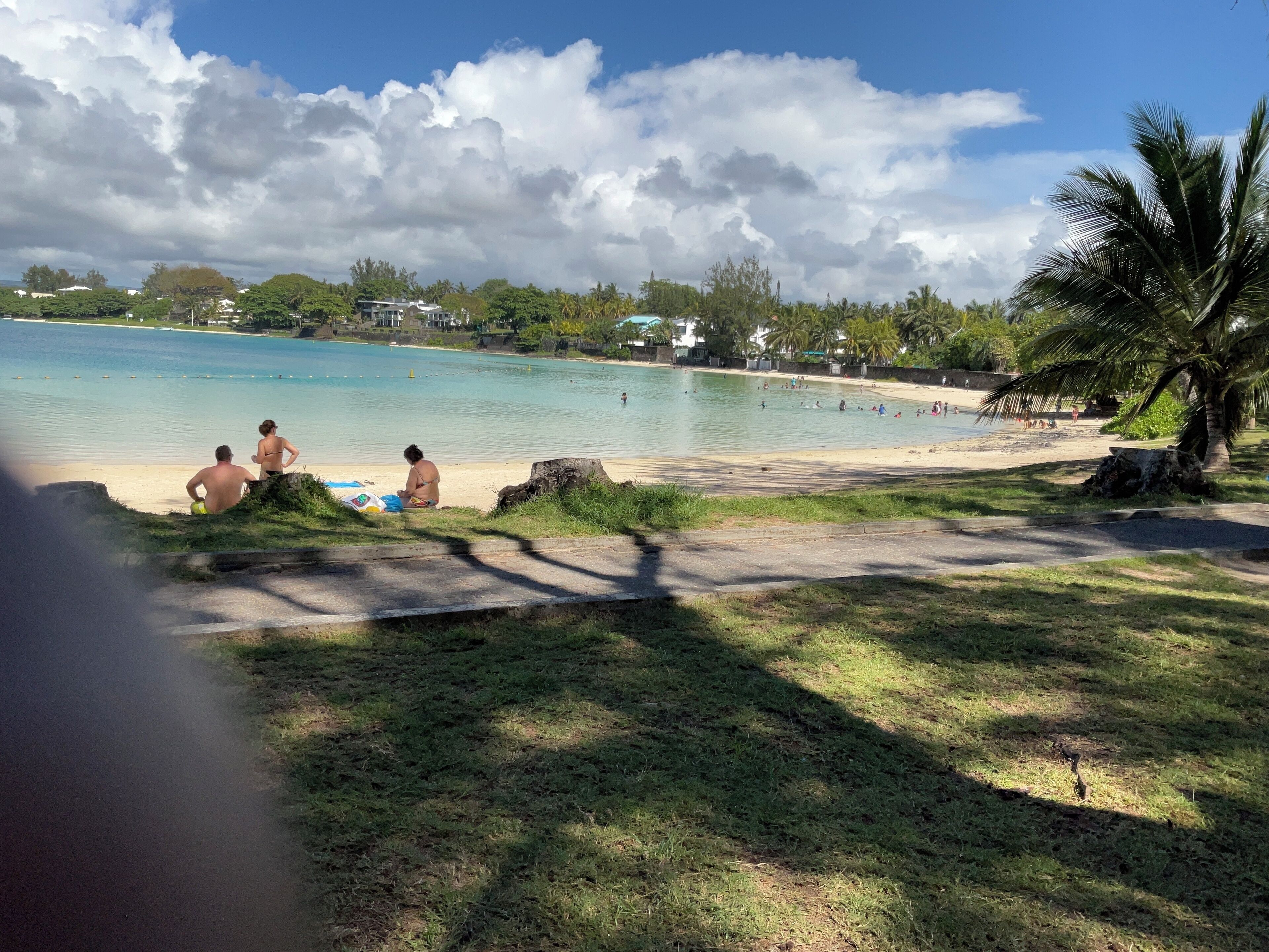 A beach with people relaxing and swimming.