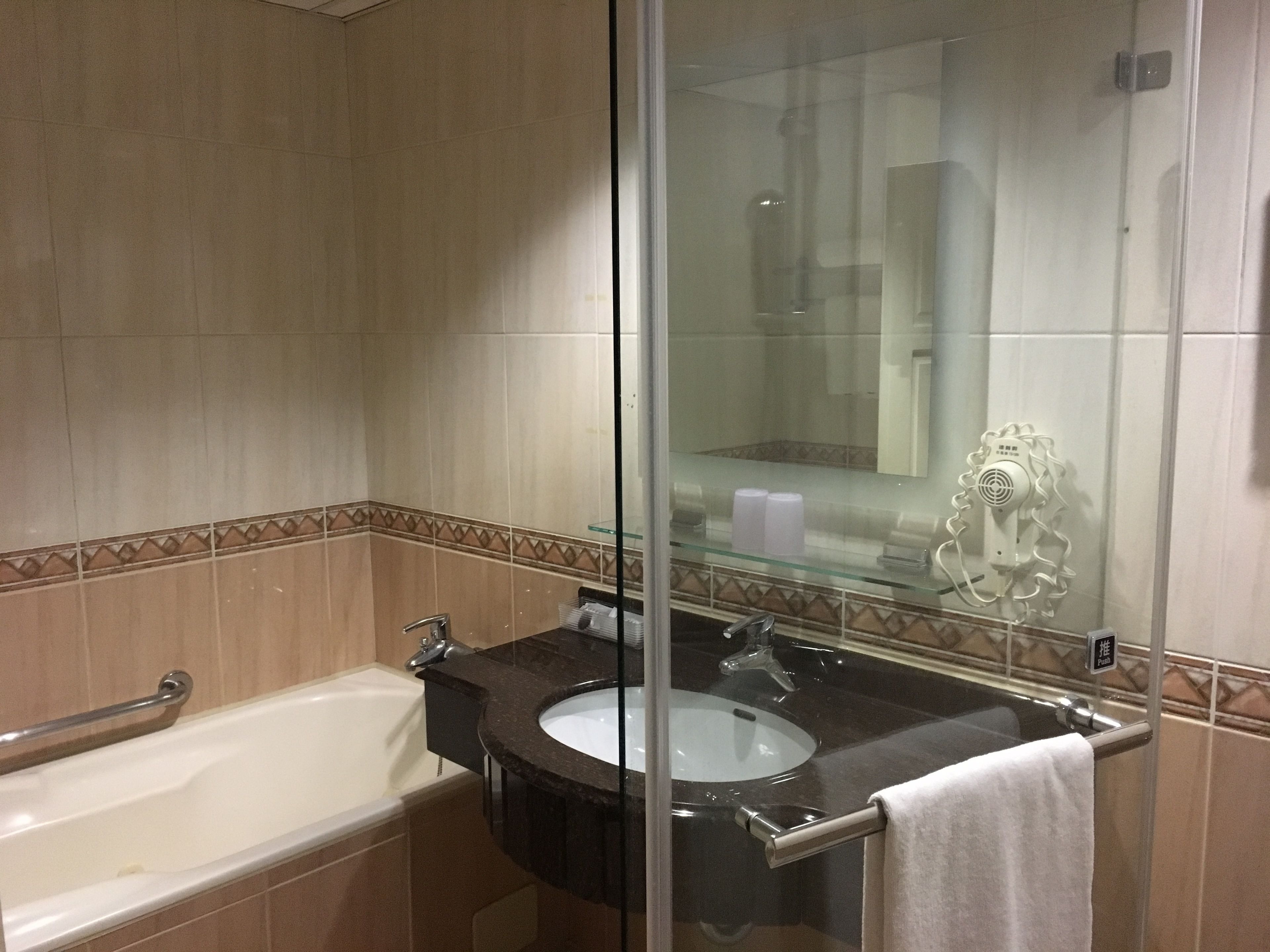 A bathroom with a bathtub, a sink, and a glass shower enclosure.