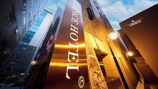 A hotel entrance with a prominent sign, a modern building facade, and a clear sky. - Capace Hotel (Seoul)