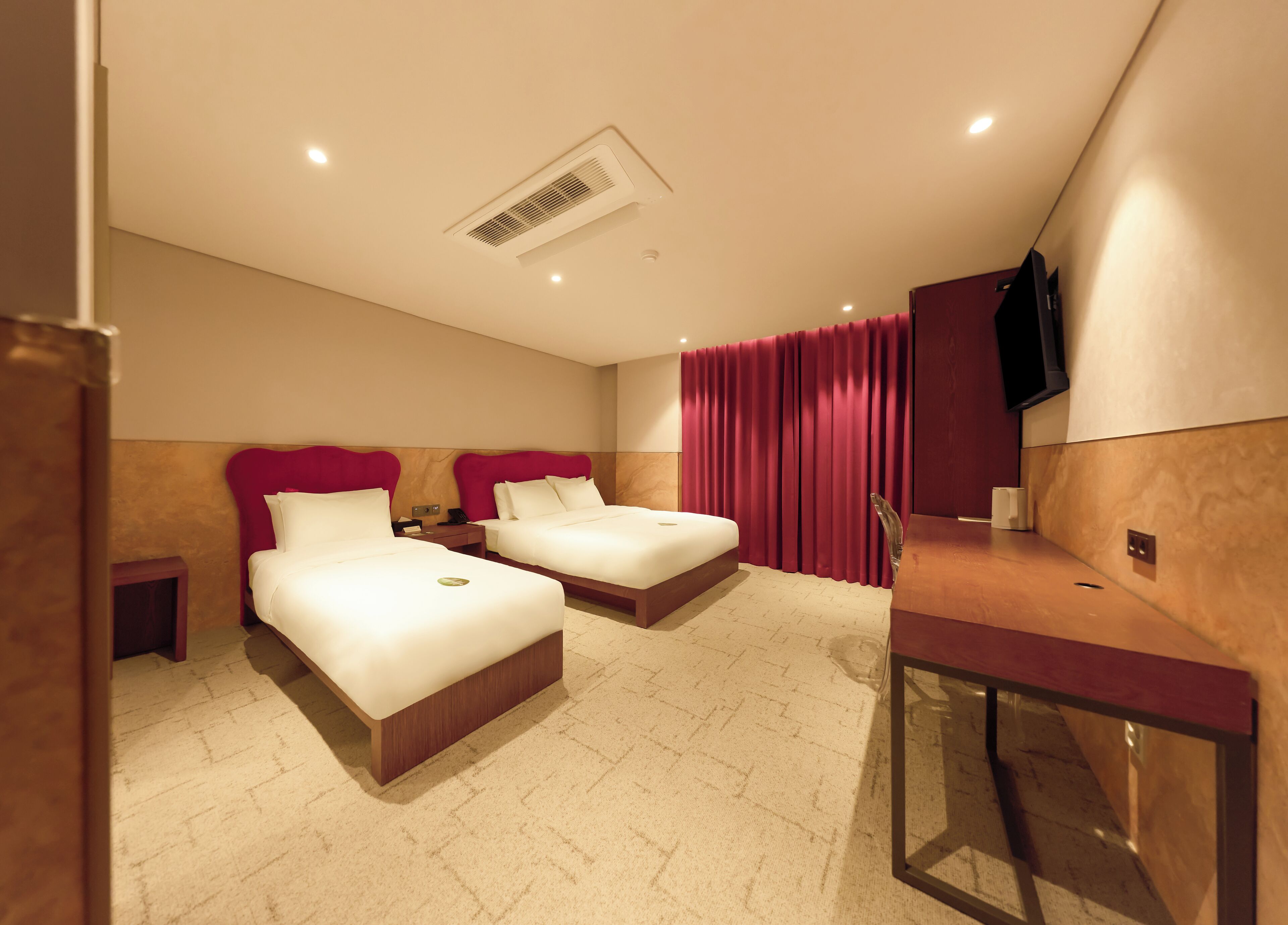 Une chambre d’hôtel avec deux lits, un bureau, une télévision et une salle de bain.