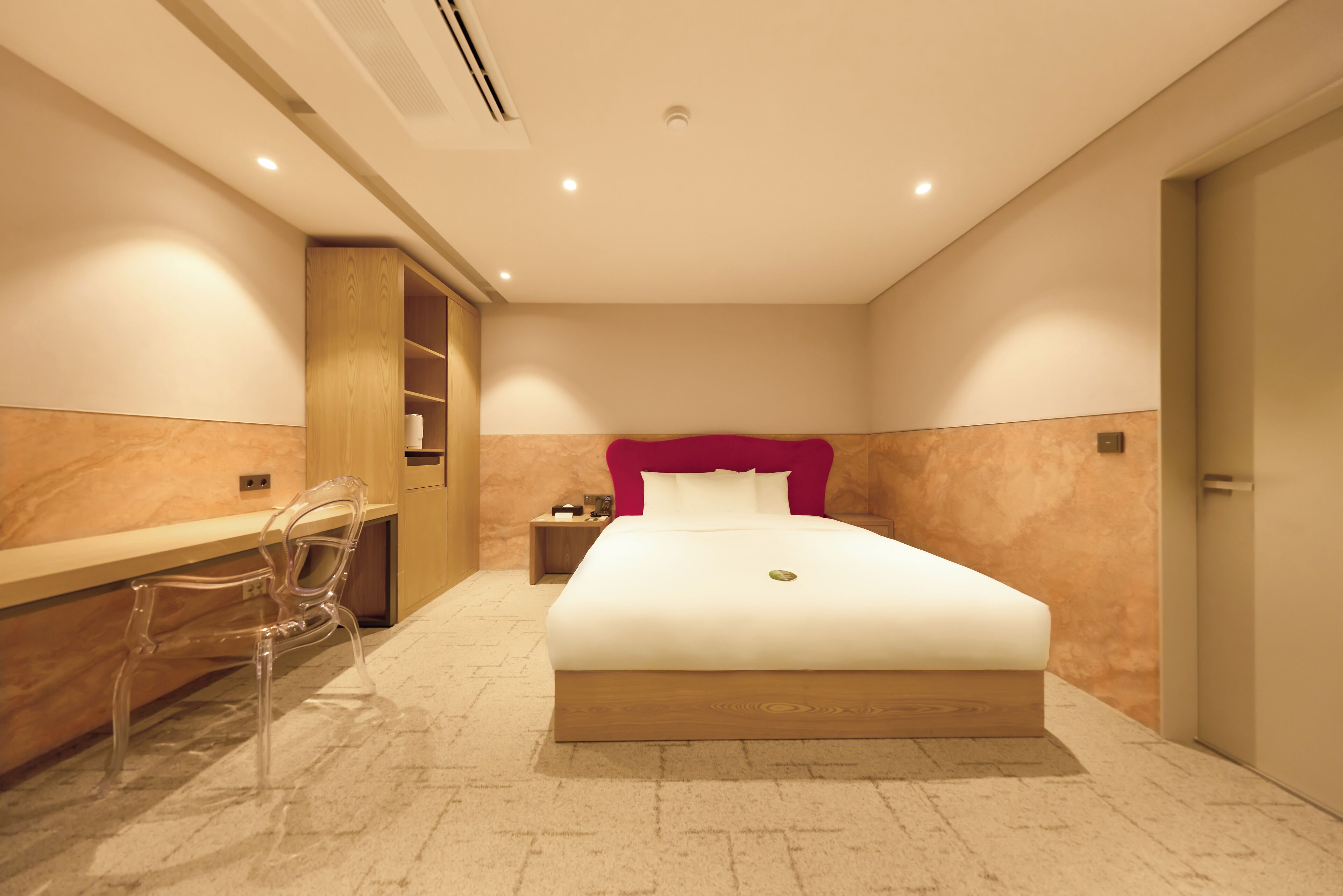 Una habitación de hotel moderna con una cama grande, un escritorio y una silla.