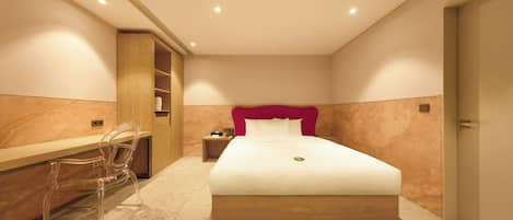 A modern hotel room with a large bed, a desk, and a chair.