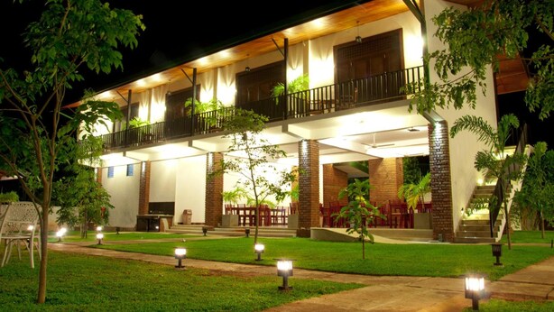 A two-story building with a covered patio area, outdoor seating, and a staircase leading to the upper level.