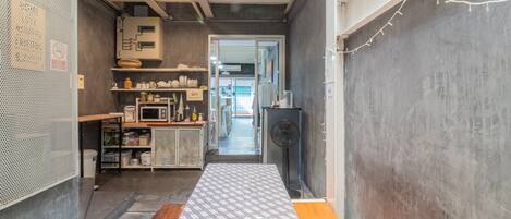 Cocina de estilo industrial con encimera central, microondas y varios electrodomésticos.