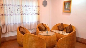 A room with wicker furniture, including two armchairs and a small round table. - Hotel Myat Nan Taw (Loikaw)