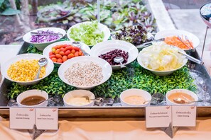 A buffet with various dishes and dressings, including Japanese and Italian options.
