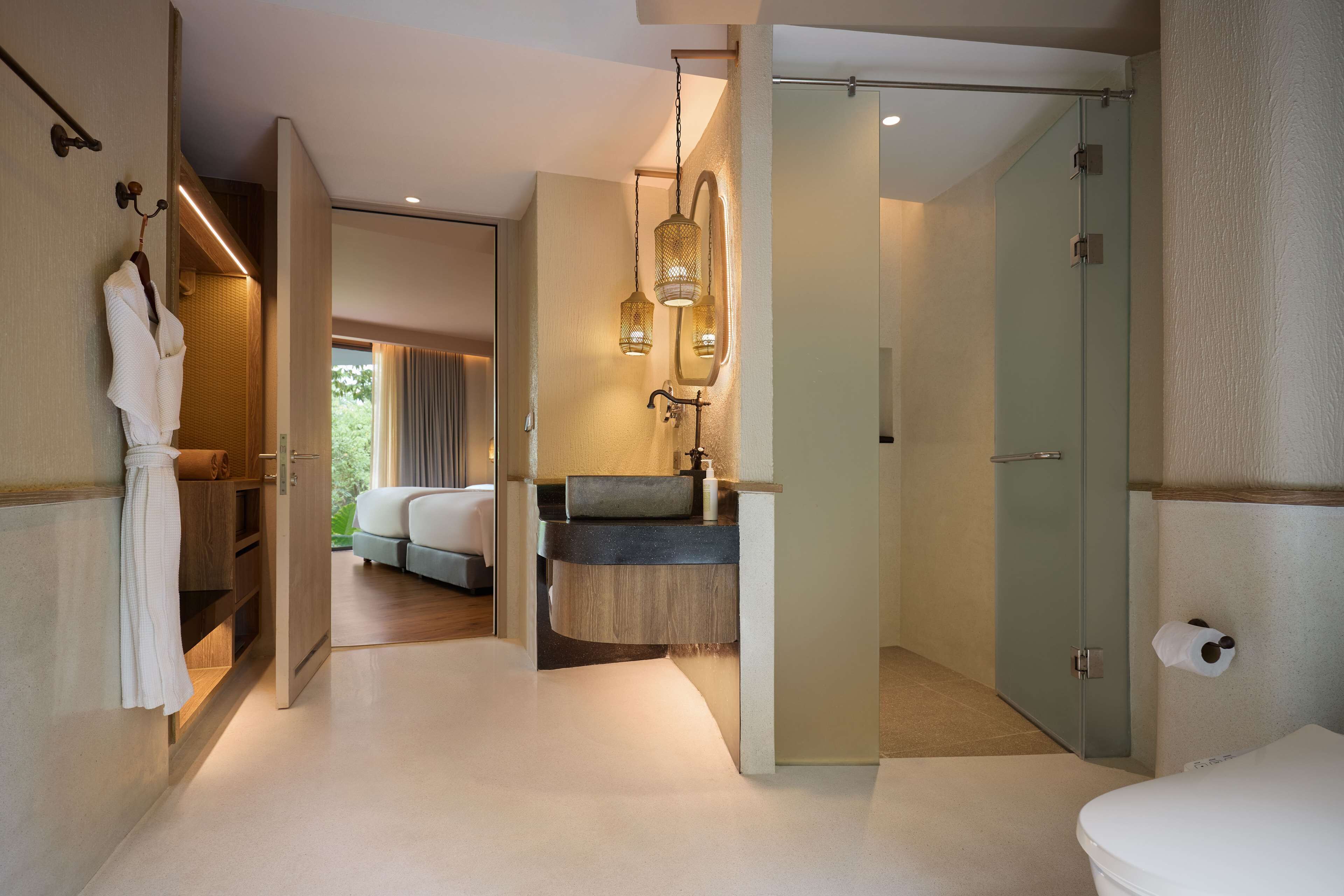 A modern bathroom with a glass shower enclosure, a wooden vanity, and a white bathtub.