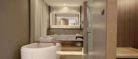 Une salle de bain moderne avec une baignoire sur pieds, un grand miroir et un meuble-lavabo en bois.