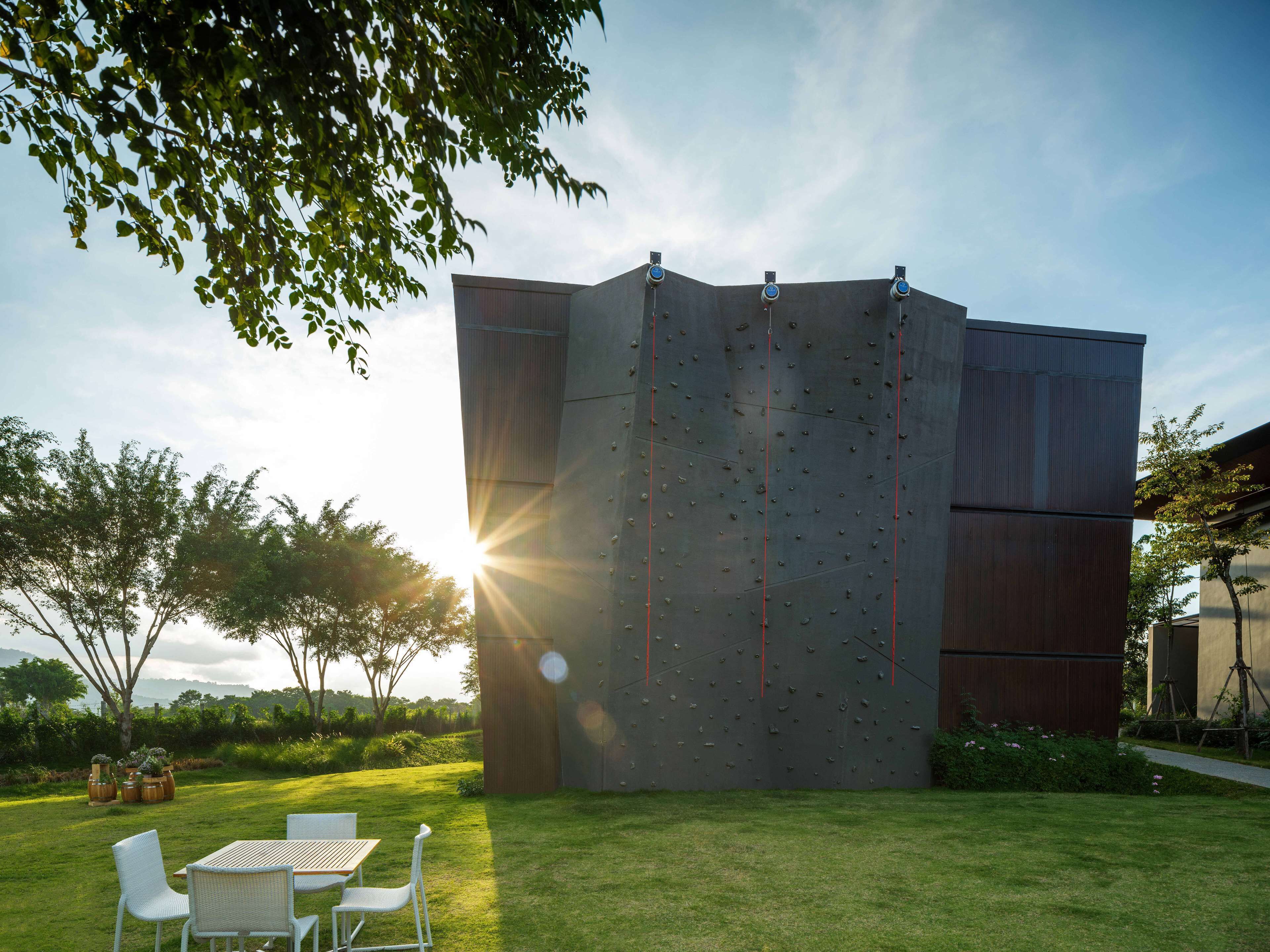 A climbing wall with a sun setting in the background.
