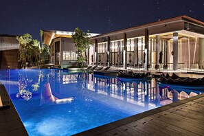 Una piscina al aire libre, tumbonas