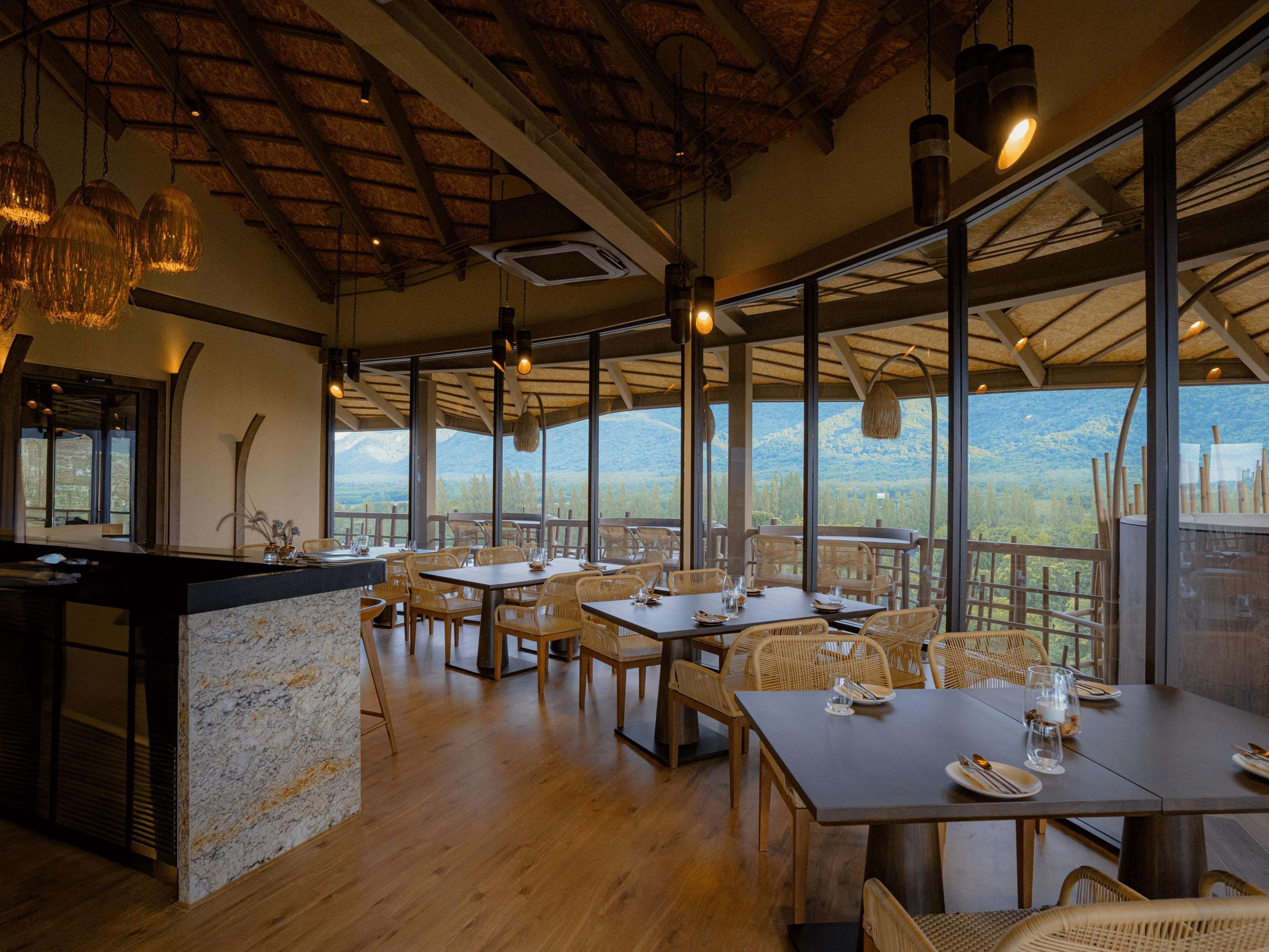 Een restaurant met terras en uitzicht op een bergachtig landschap.