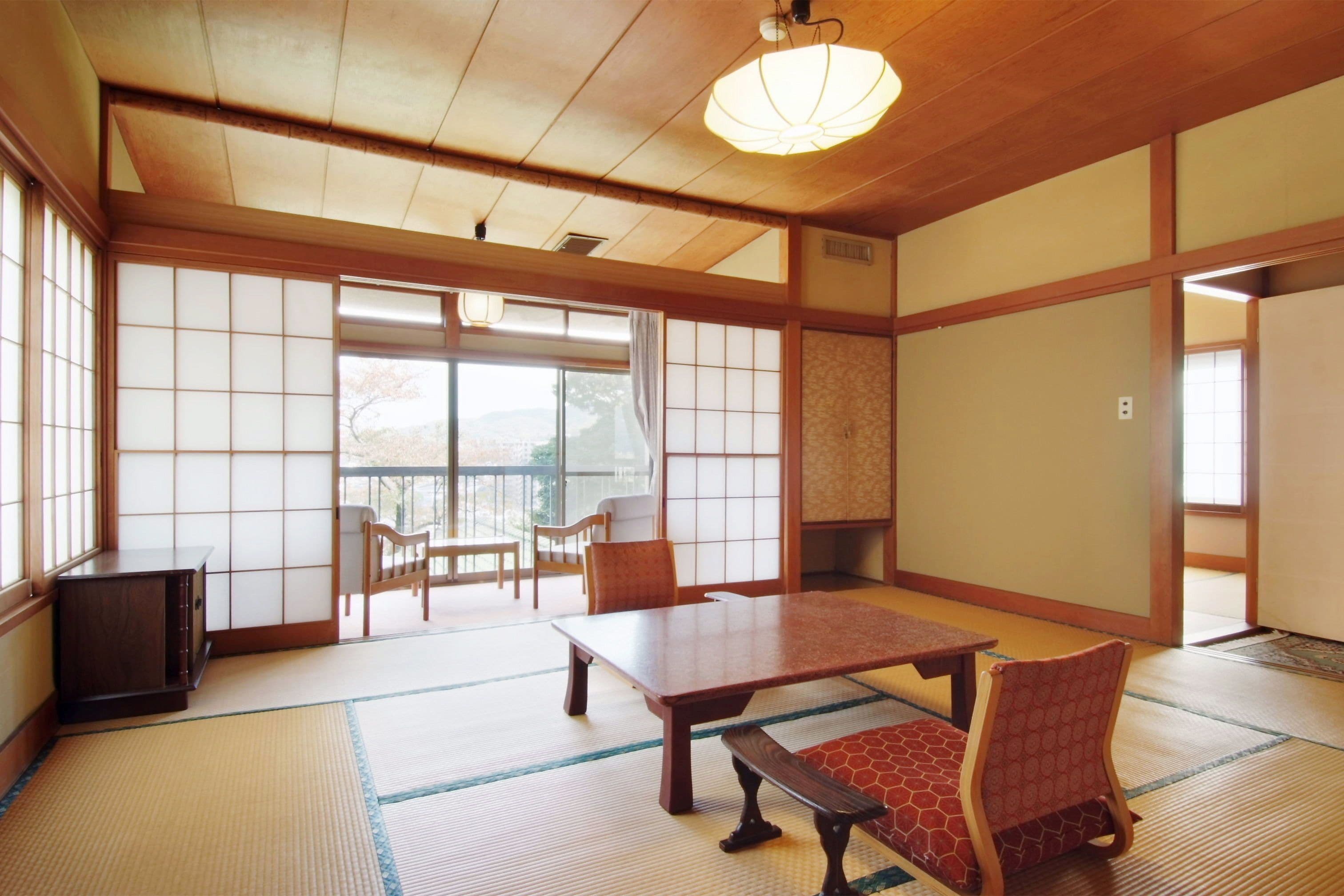 Una habitació japonesa tradicional amb fusta de tatami, una taula baixa i portes corredisses.