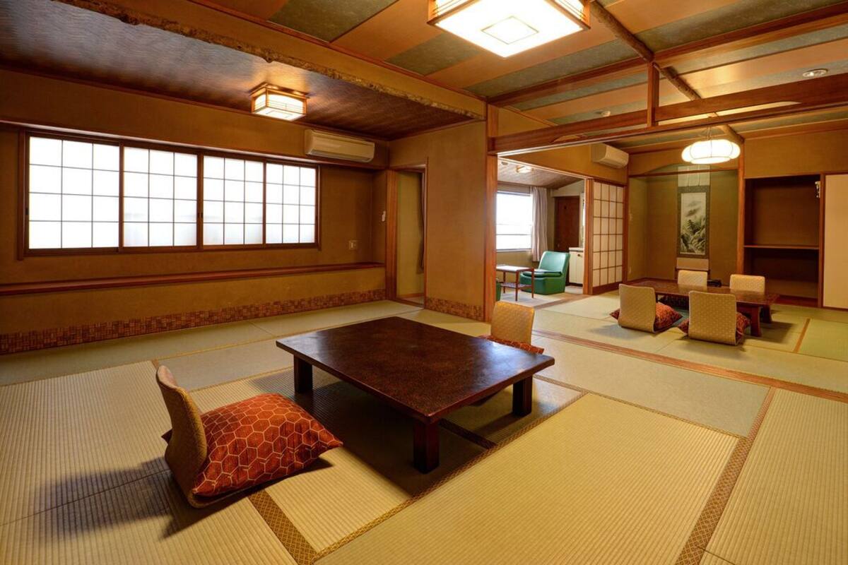 Ett traditionellt japanskt rum med tatamimattor på golvet, ett lågt träbord och en skjutdörr.