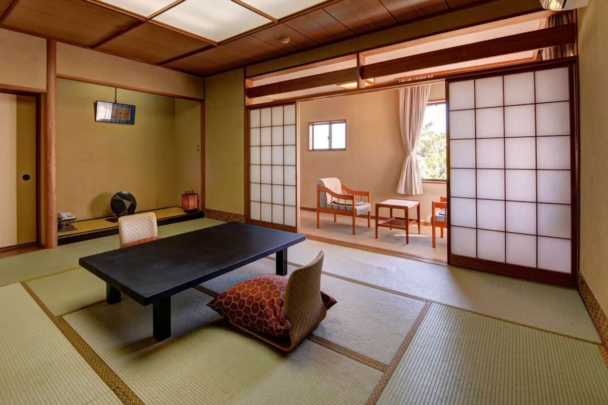A traditional Japanese room with tatami flooring, a low table, and sliding doors.