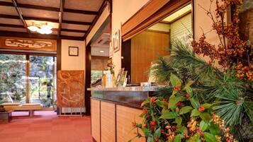 A reception area with a wooden counter, a clock, and a view of the outdoors.