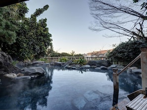 Un espace piscine extérieur paisible, doté d’une terrasse en bois et d’une clôture en bambou.
