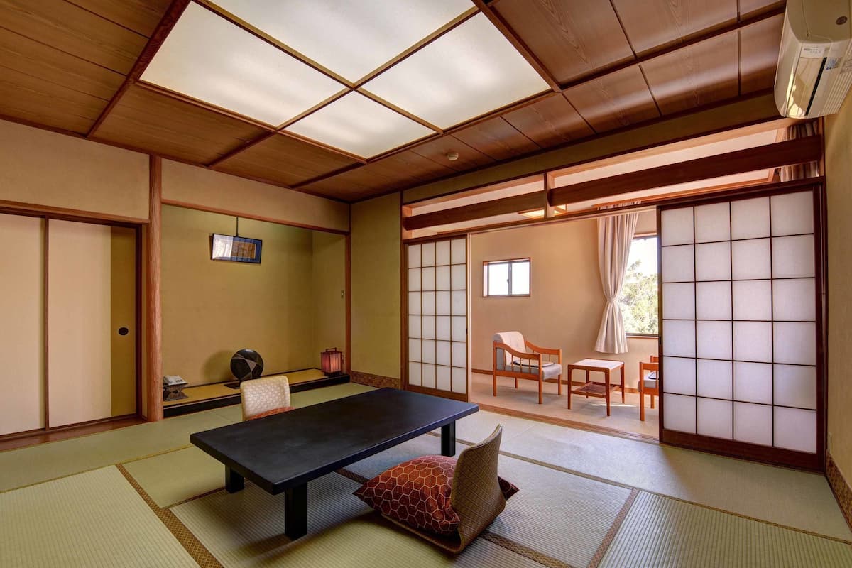 A traditional Japanese room with tatami flooring, a low table, and sliding doors.